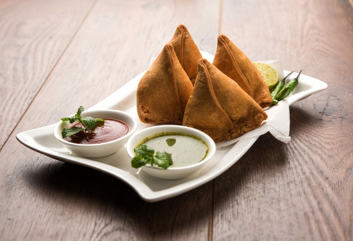 Mixed Indian starters including samosas and wings, perfect for beginning a meal.