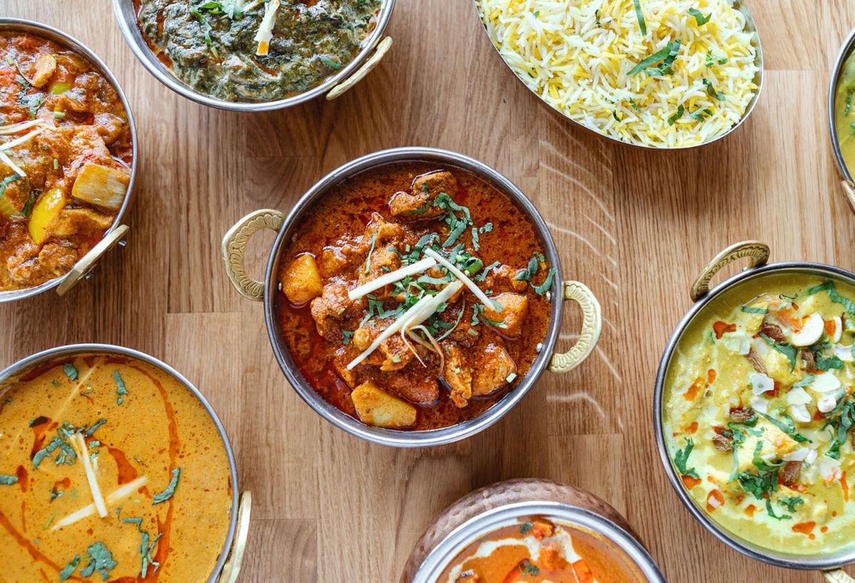 Variety of Indian dishes with chicken curry, paneer curry and rice